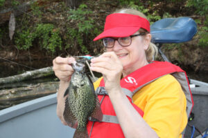 Marilyn Black admires a hand-tied jig that was fished beneath a bobber to catch springtime Black Crappies. 