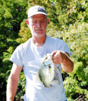 Jamie Kellum with a nice back country lake crappie. During summer crappie tend to stage just off from cypress stumps. Cast and retrieve slow with 1/8 and 1/32 oz jigs. (Photo by Richard Hines)