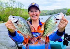 Author Madalyn Roberts triumphantly displays her catch after a challenging day on the water, which included a few healthy Taylorsville white and black crappie. (Photo by Jay Jackman)
