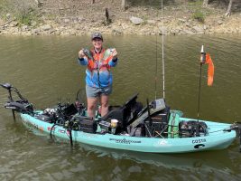 Although Author Madalyn Roberts had taken off her PFD to throw on her jersey for a rare photo op on the water, she chose to share this photo to demonstrate just how significant the impact is of a hull filled with water, and how it effects the balance and weight distribution of the kayak, an especially dangerous situation in high winds. (Photo by Jay Jackman)