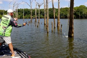John Harrison pulls a crappie from timber. He prefers plastic as his first choice. His preferred method is to pitch past the fish and let the jig pendulum down to entice a strike. (Photo: Tim Huffman)